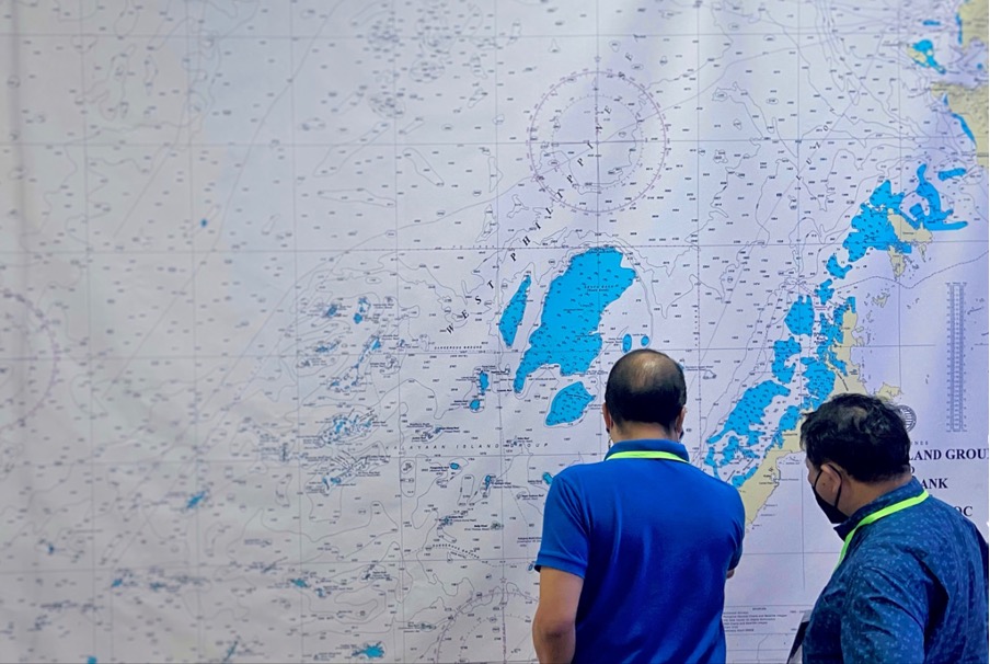 RE-INVEST Project II team leaders examine the map of Kalayaan Island Group, one of the study sites for the project's research activities. (Image credit: Socio-Economics Research Division, DOST-PCAARRD)